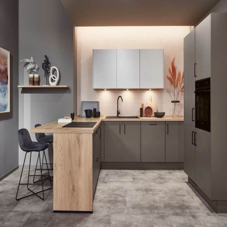 Einbauküche kaufen: Exklusive U-Küche mit Holztresen Exklusive U-Küche in Grau mit Tresen aus Holz, Barhockern und indirekter Beleuchtung