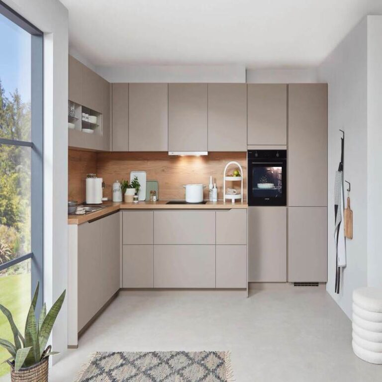 Neue Küche: Musterküche in Kaschmir Musterküche in Kaschmir als L-Küche mit Holzrückwand und Backofen im Hochschrank